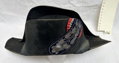 un chapeau noir orné d'un ruban rouge et bleu