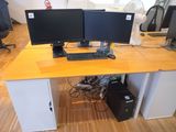 two computer monitors sitting on a desk with a keyboard and mouse