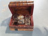 a small wooden box with glasses and a bottle in it