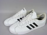 des baskets Adidas blanches et noires sur un fond blanc