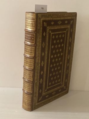 un vieux livre posé sur une table blanche à côté d'un mur blanc