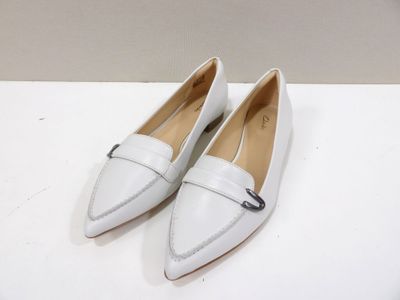 a pair of white shoes sitting on top of a white table