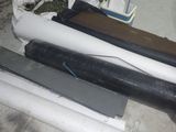 plusieurs rouleaux de plastique noir et blanc posés sur un sol en béton