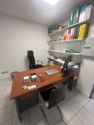 un bureau sur lequel se trouve un ordinateur portable, dans un coin de la pièce