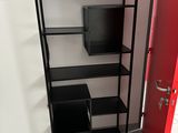 une porte rouge et une étagère noire dans une pièce