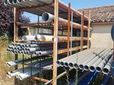 many pipes that are stacked on a rack in the yard