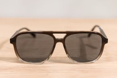 sunglasses on a wooden table with a white wall in the background