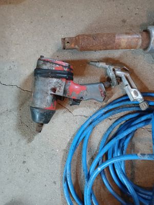 un tuyau bleu et un marteau par terre