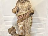 statue d'une femme accompagnée d'un chien, posée sur un socle dans une pièce