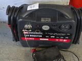 a black blower sitting on the ground next to a red cone