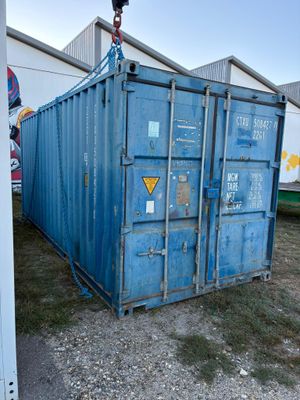 a large blue container sitting in the middle of a yard