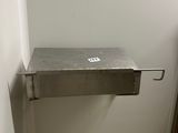 a metal sink in the corner of a small bathroom