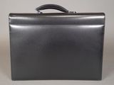 black leather briefcase sitting on top of a white table