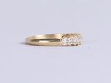 a close up of a gold ring with three diamonds on it