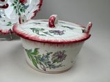 a bowl with a lid and a plate with a flower design on it