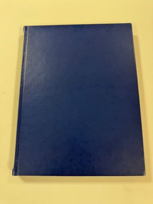 a blue book sitting on top of a table next to a white wall