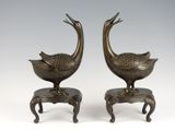 pair of bronze birds on pedestals on white background