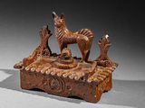 an old wooden statue of a dog and a bird on a table