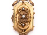une image représentant une broche en or ornée de perles