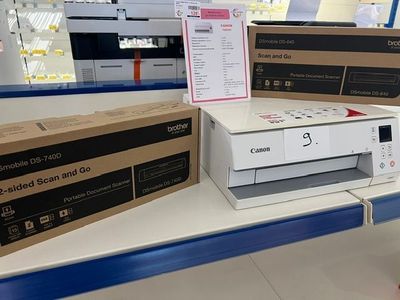 une imprimante posée sur une étagère dans un magasin