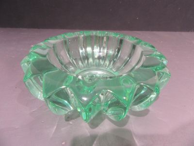 un saladier en verre vert posé sur une table blanche