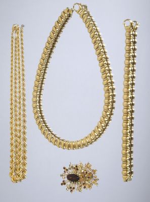 a gold necklace, bracelet, and broochet set