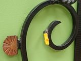 a black iron fence with a yellow flower on it