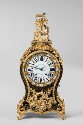 an image of a gold and black clock sitting on top of a table