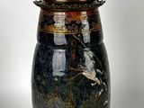 a large vase with a lid on a stand