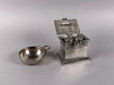 a small silver box and a silver cup on a table