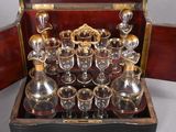 bottles and glasses in a wooden case on a table