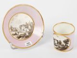 two cups and a saucer with a picture of a town on them