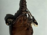 un sac en papier brun muni d'une anse, accroché à un mur