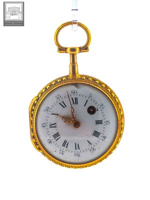 a gold pocket watch with roman numerals on it