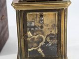 a small clock that is sitting next to a wooden box