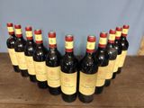 six bottles of red wine lined up in a row on a wooden table