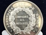un gros plan d'une pièce de monnaie posée sur une étiquette blanche, sur une surface noire
