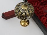 brass door knob in a red velvet box with a red handle