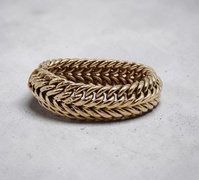 gros plan d'une bague en or sur une surface blanche