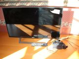 a flat screen tv sitting on top of a wooden table