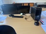 a desk with two computer monitors and a keyboard on it