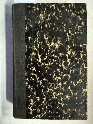 un vieux livre à la couverture noire posé sur une table