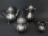 three pieces of silver tea and coffee set on a black background