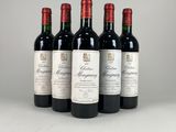quatre bouteilles de vin rouge sont alignées sur une table