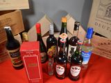many bottles of wine sitting on a table next to boxes of wine
