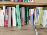 a book shelf with many books on it and a toothbrush in front of it
