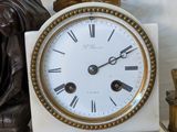 a white and gold clock with roman numerals on top of it