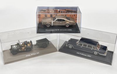 trois modèles de voitures différents dans une vitrine transparente