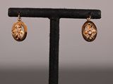 gros plan d'une paire de boucles d'oreilles sur un support