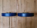 une paire de lampes de table en laiton et bleu posées sur un plateau en marbre